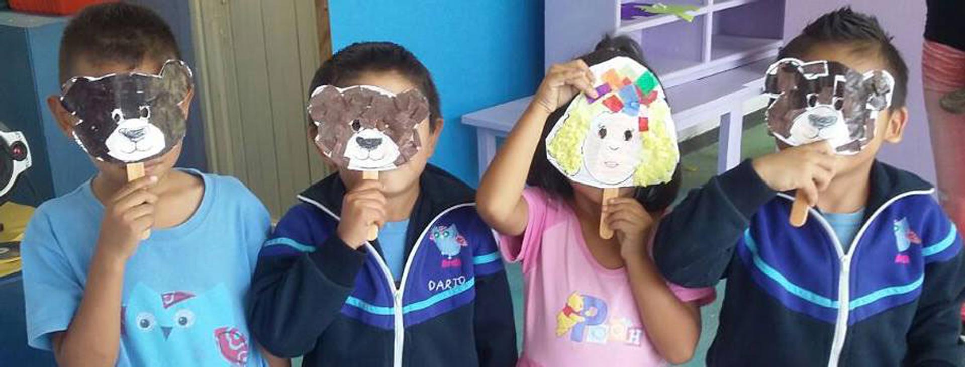 Niñas y niños mostrando trabajos realizados en clase